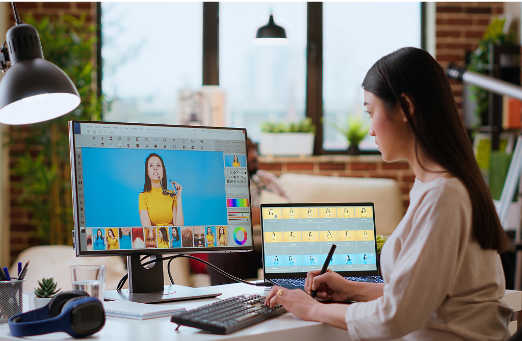 Asian graphic designer using editing software for photo retouching — offshore creative role